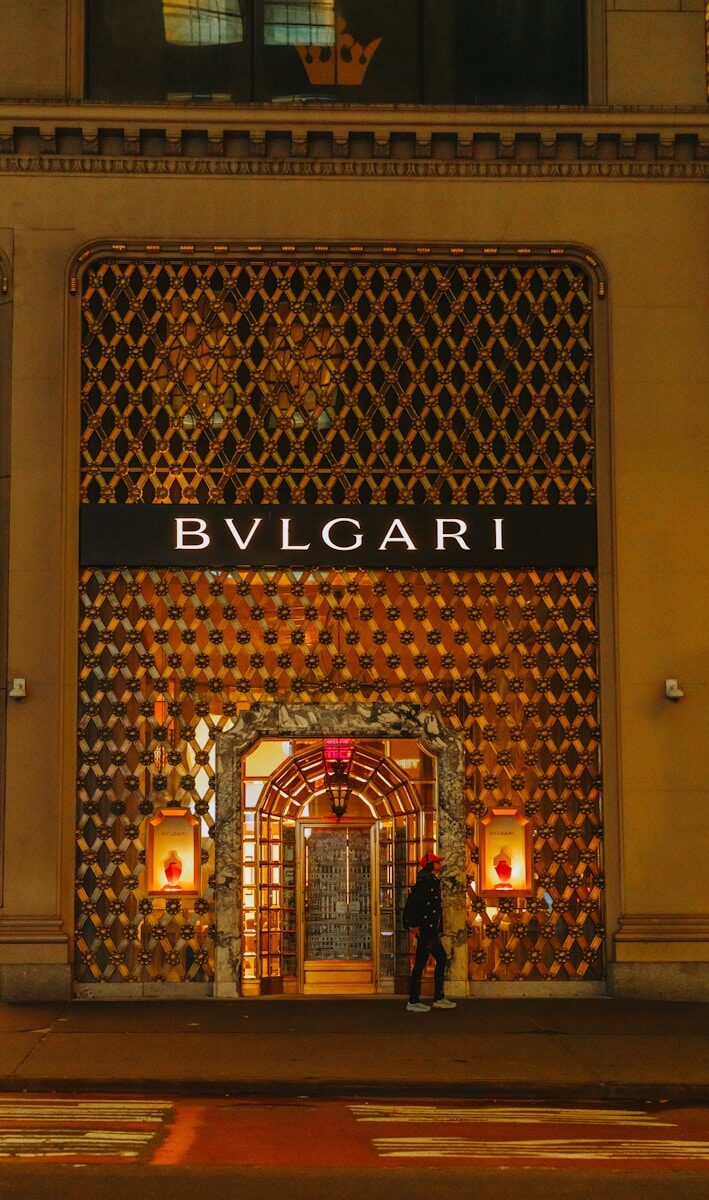 Bulgari store entrance at night with ornate gold detailing.